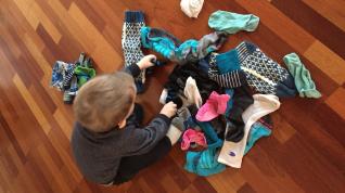 Gutt finner et par sokker fra en haug