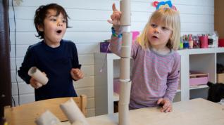To barn bygger tårn med toalettruller